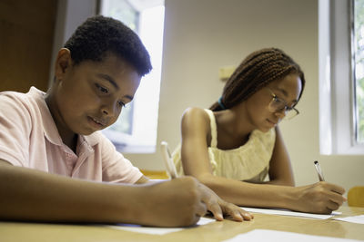 Side view of boy using laptop at home