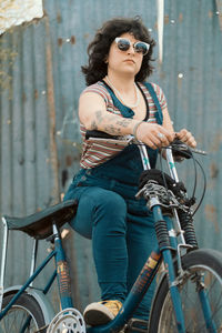 Low angle portrait of beautiful woman with vintage style posing with her bicycle