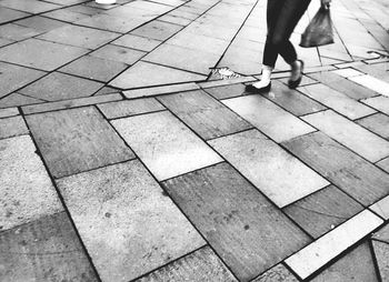 Low section of woman walking on footpath