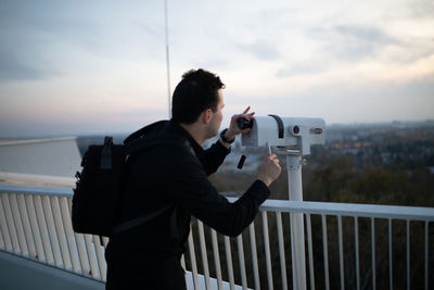 Man photographing against sky