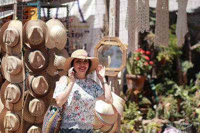 Portrait of smiling woman wearing hat at market