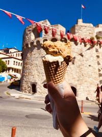 Midsection of woman holding ice cream in city