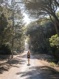 Rear view of woman walking on road