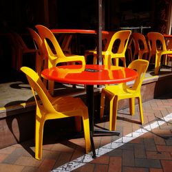 Empty chairs and tables at sidewalk cafe