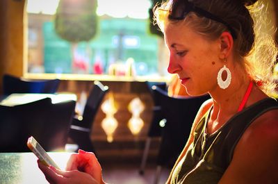 Woman using mobile phone in restaurant