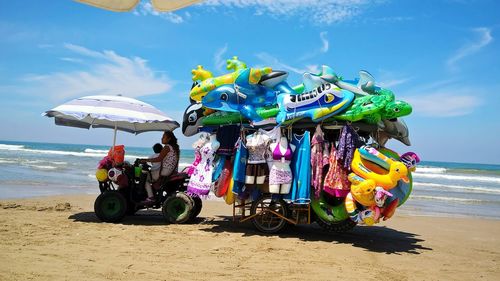 Mother and son riding quadbike by market stall at beach