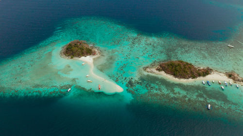 Aerial seascape bay with tropical island and sand beach, turquoise water and coral reef. bulog dos