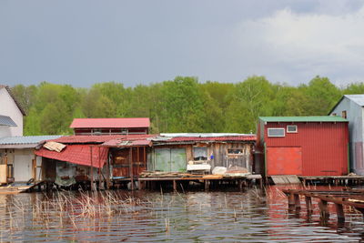 Houses by lake against sky