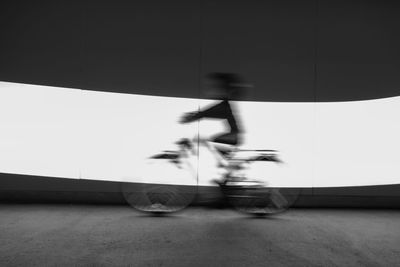 Low section of man jumping on bicycle