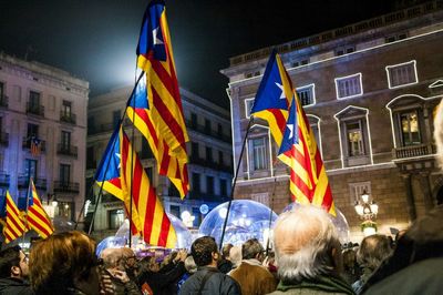 People by flags in city at night