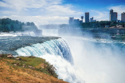 Scenic view of waterfall against sky