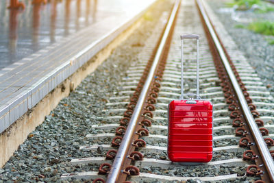 Close-up of wheeled luggage on railroad tracks