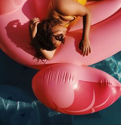 High angle view of young woman in on pool raft at swimming pool