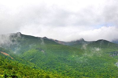 Scenic view of mountains against cloudy sky