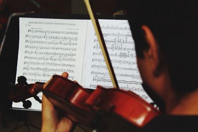 Rear view of man playing violin