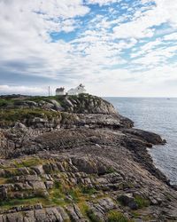 Rock formations by sea against sky
