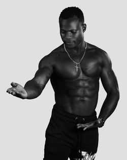 Shirtless man standing against white background