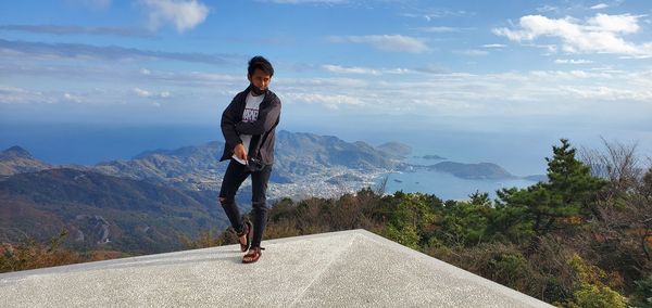 Full length of man standing on mountain against sky