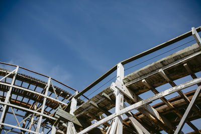 Low angle view of wooden structure against blue sky