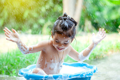 Full length of shirtless boy playing in water
