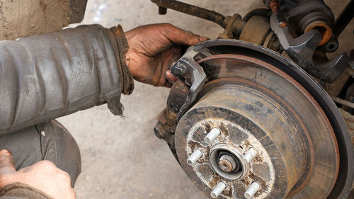 Cropped hands of mechanic working in auto shop