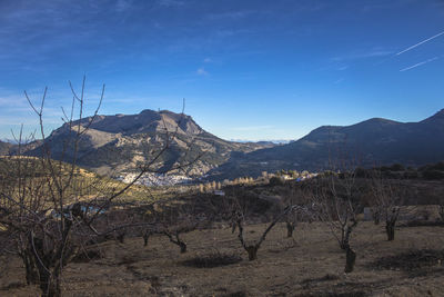 Scenic view of mountains against blue sky