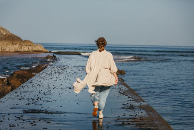 Man standing on beach against clear sky