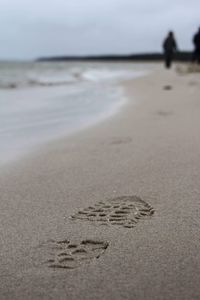 Close-up of footprints on sand at beach