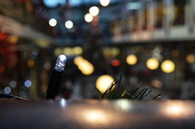 Close-up of illuminated lamp on table at night