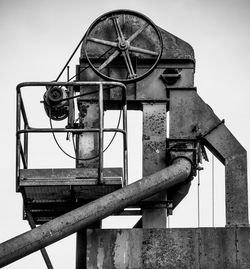 Low angle view of old machinery against sky