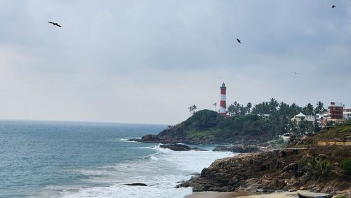 Seagulls flying over sea against sky