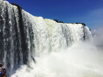 Low angle view of waterfall against clear sky