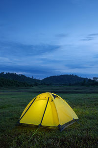 Yellow tent on field against sky