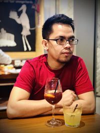 Portrait of man drinking glasses on table at restaurant