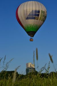 Low angle view of hot air balloon against clear blue sky