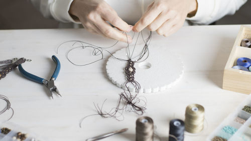 High angle view of woman working with thread on table