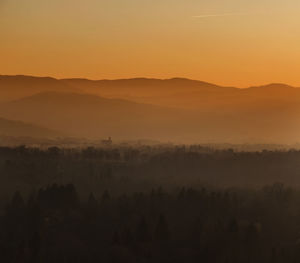 Scenic view of silhouette landscape against orange sky