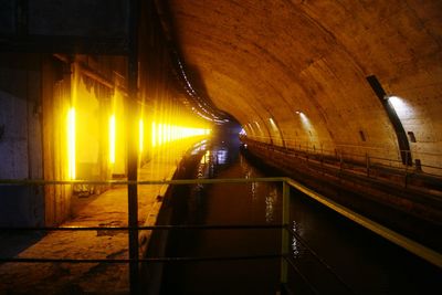 Illuminated railroad tracks in tunnel