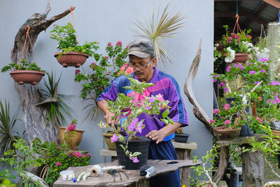 Man standing by potted plants