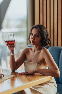 Portrait of young woman sitting on table