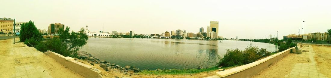 Panoramic view of lake and city against clear sky