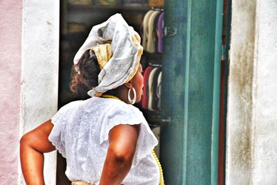 Rear view of woman standing against wall