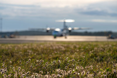 The plane is at the airfield. the airpairplane is out of focused, unfocused. waiting for travel 