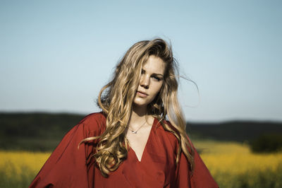 Portrait of woman on field against clear sky