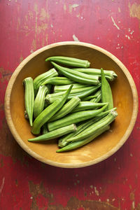 Okra in a bowl on a red table