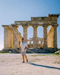 Full length of man standing in front of historical building