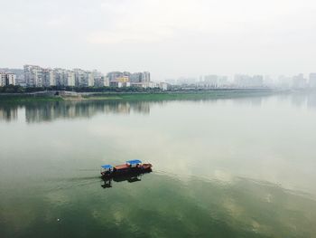 Boats in river with buildings in background