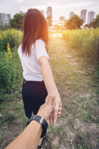 Rear view of woman with arms raised on field