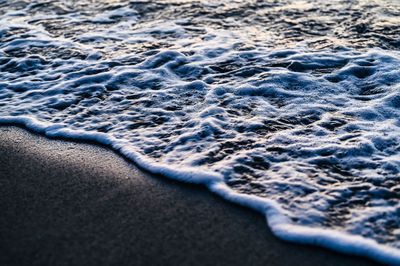 High angle view of surf on sea shore