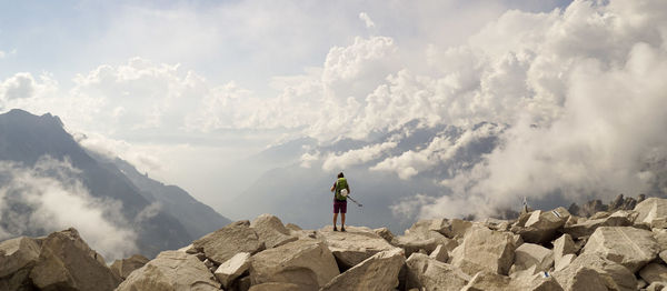 Panoramic view of man standing on mountain against sky